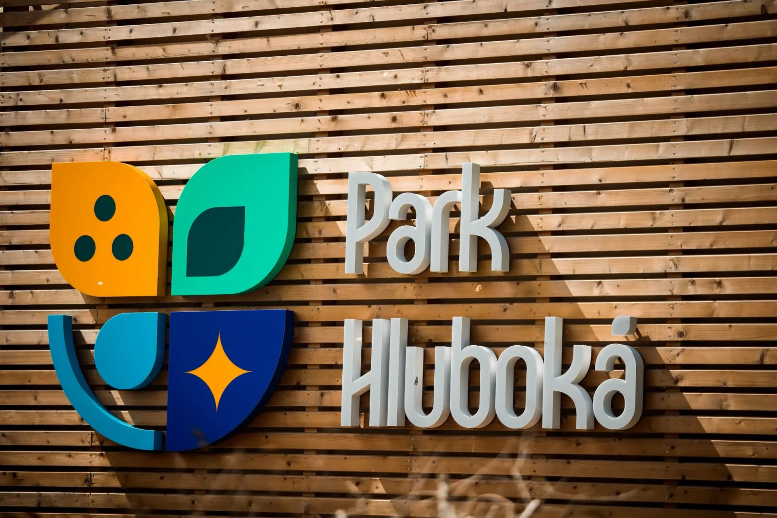 Logo Park Hluboká na dřevěné fasádě resortu